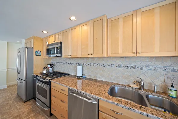 a kitchen that has a sink cabinets counter space and appliances