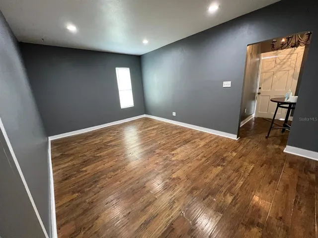 an empty room with wooden floor and a window