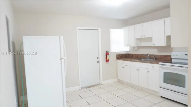 a kitchen with granite countertop white cabinets and white appliances