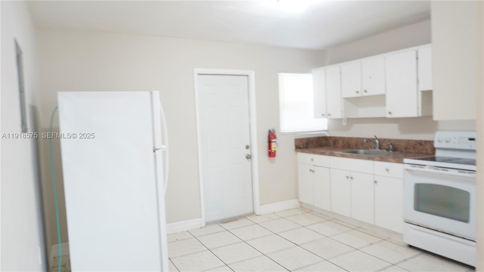 13701 Southwest 266th Street, Unit 13701 Homestead, FL 33032 - Photo 3 of 10 a kitchen with granite countertop white cabinets and white appliances