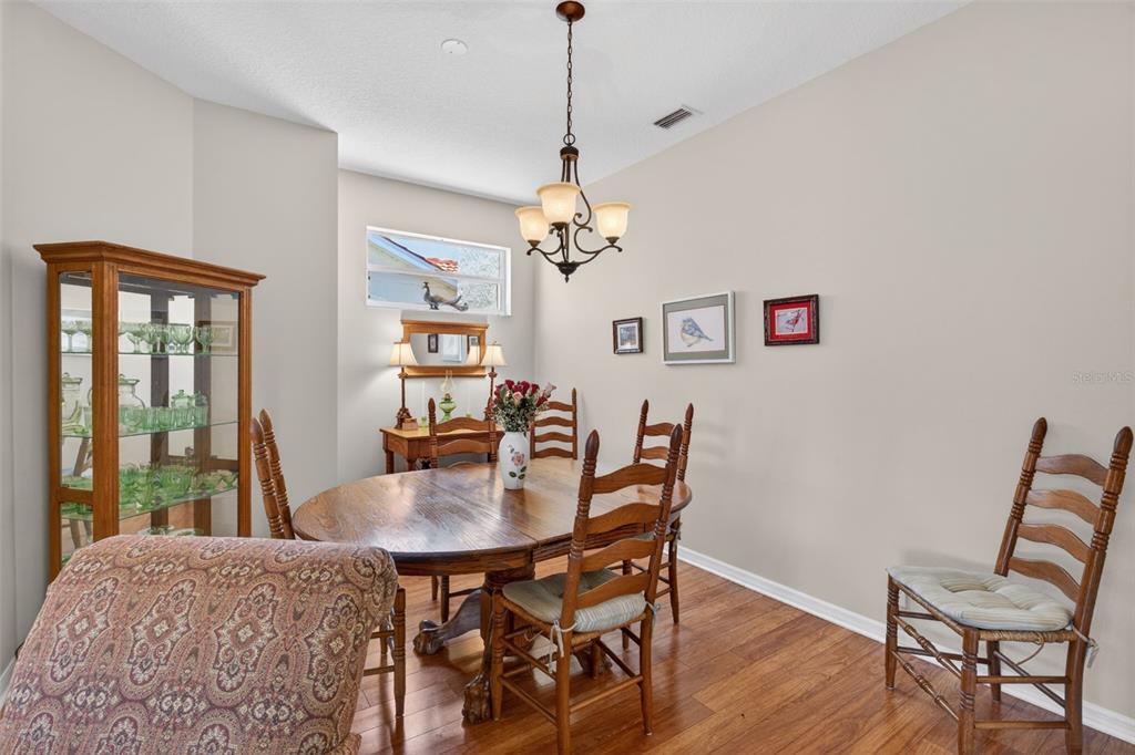 4266 Summertree Road Venice, FL 34293 - Photo 31 of 64 a dining room with furniture a window and wooden floor