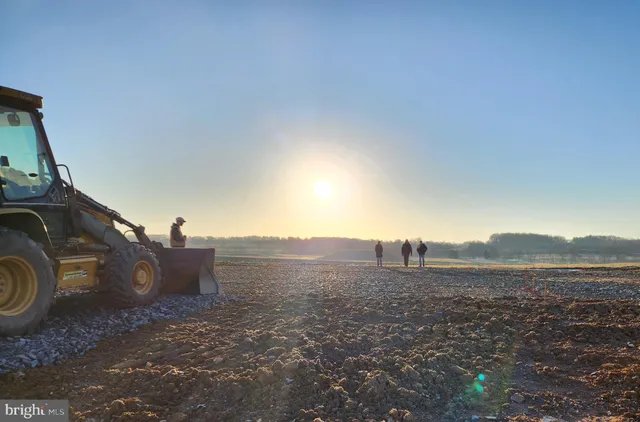 a view of a dry yard with wooden fence