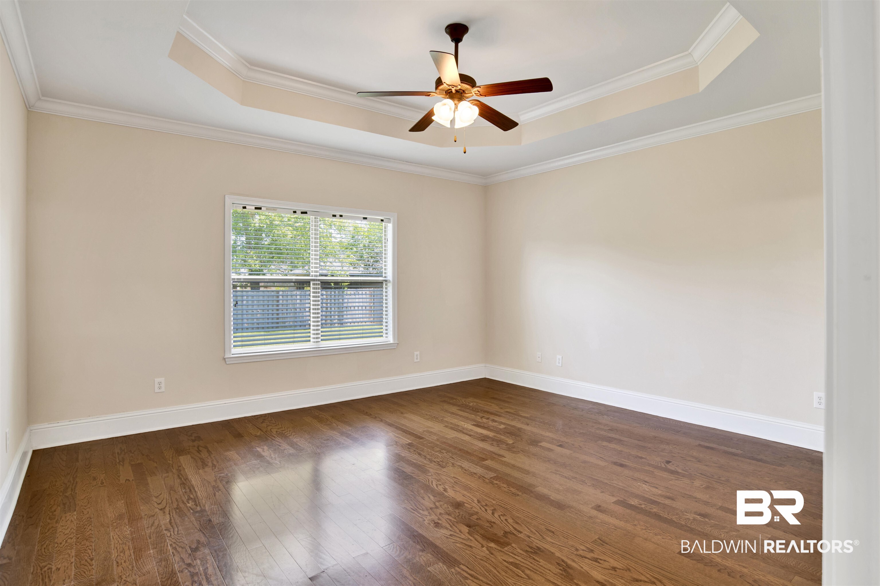10910 Roanoke Loop Daphne, AL 36526 - Photo 25 of 33 Unfurnished room featuring ornamental molding, dark wood finished floors, and a tray ceiling