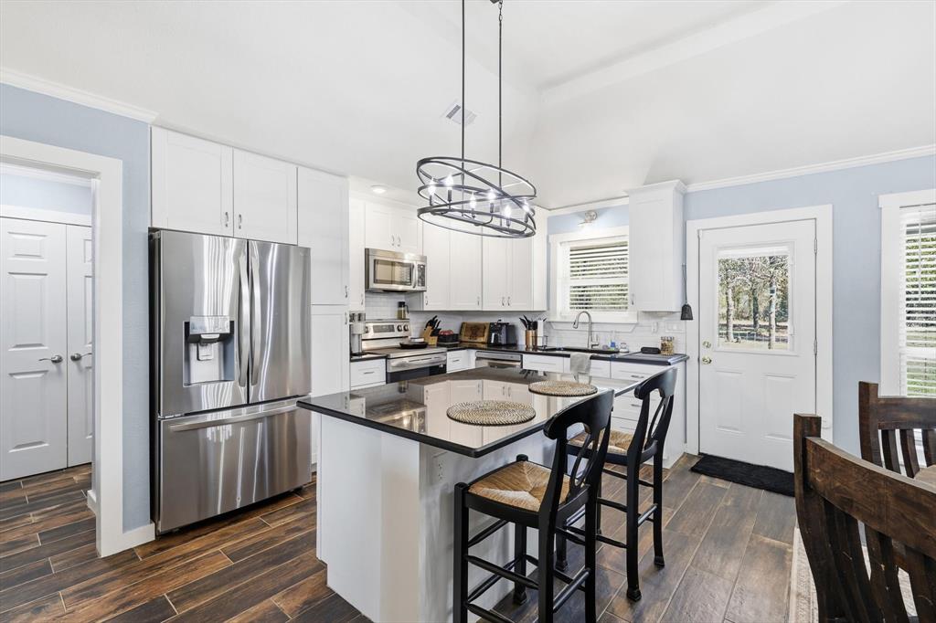 a kitchen with stainless steel appliances a dining table chairs and chandelier