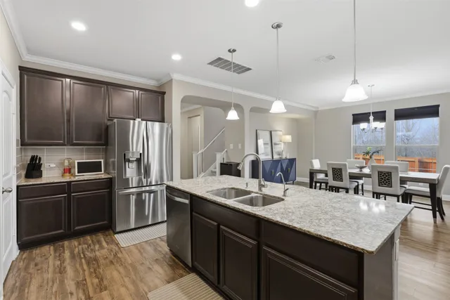 a kitchen with stainless steel appliances granite countertop a sink refrigerator and cabinets