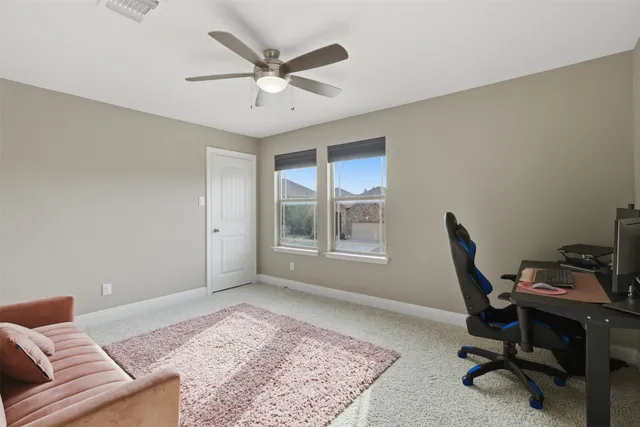 a view of a workspace with furniture and a window