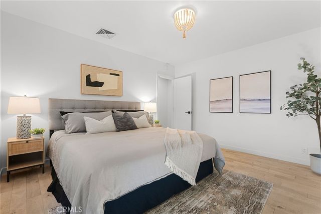 a bedroom with a bed and a painting on the wall