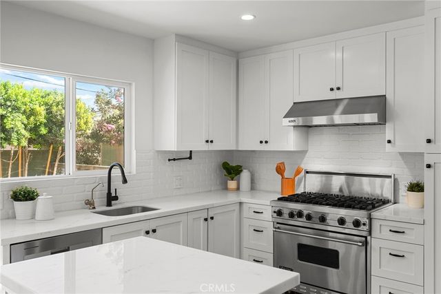 a kitchen with white cabinets and appliances