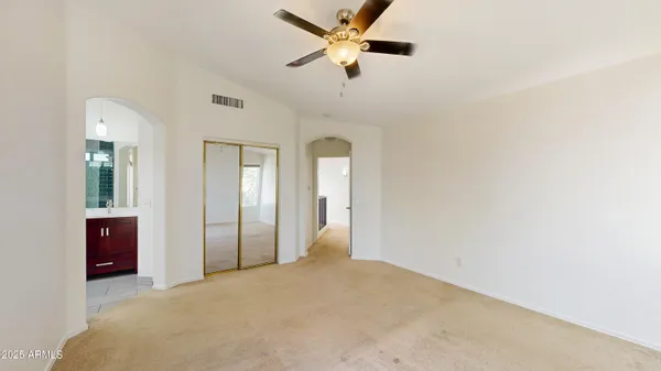a view of a big room with closet and a ceiling fan