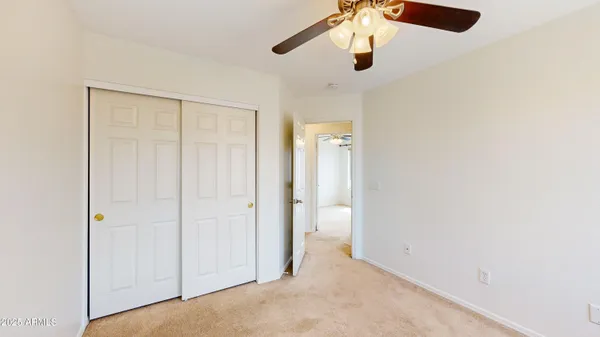 an empty room with chandelier fan