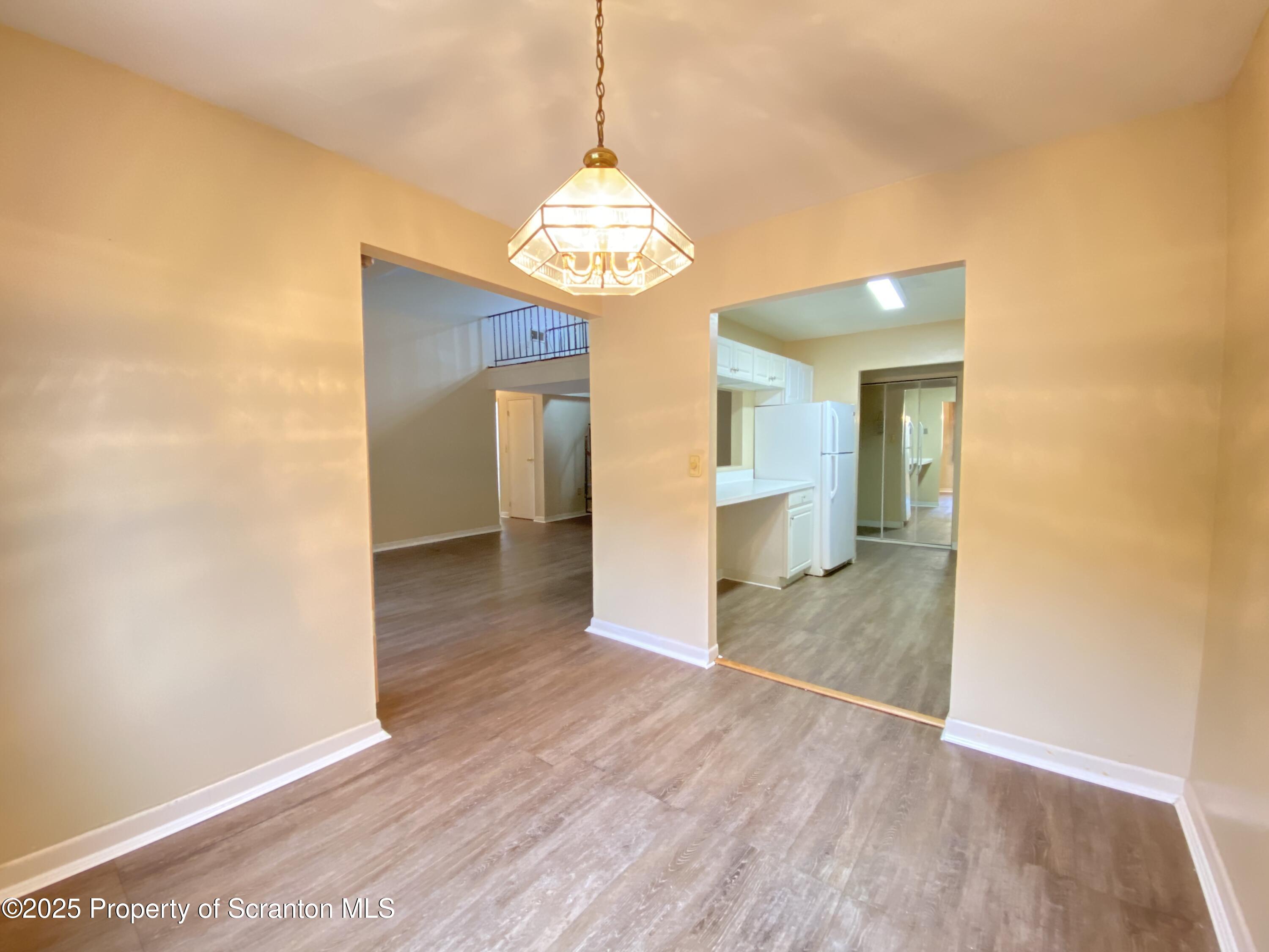1309 Summit Pointe Scranton, PA 18508 - Photo 9 of 33 a view of a hallway with wooden floor and a kitchen