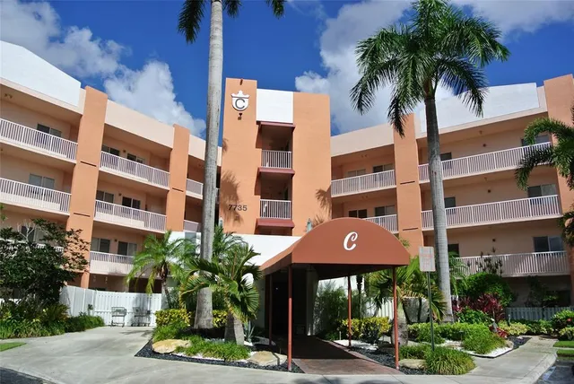 a front view of a building with palm trees