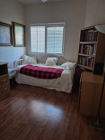 a spacious bedroom with a bed and a book shelf