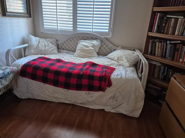 a bedroom with bed and a book shelf