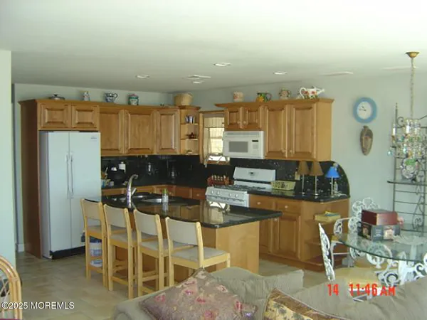 a kitchen with stainless steel appliances kitchen island granite countertop a table and chairs