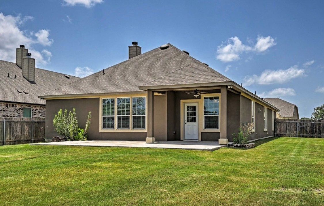 31443 Kingsway Road Georgetown, TX 78628 - Photo 38 of 40 A well-maintained lawn stretches out from a concrete patio, leading to a covered porch.