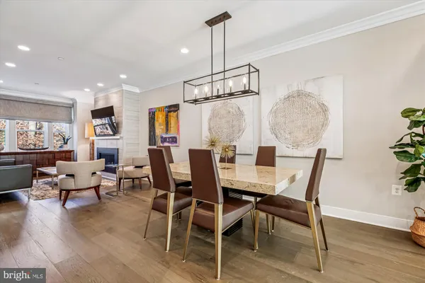 a dining room with furniture a chandelier and wooden floor