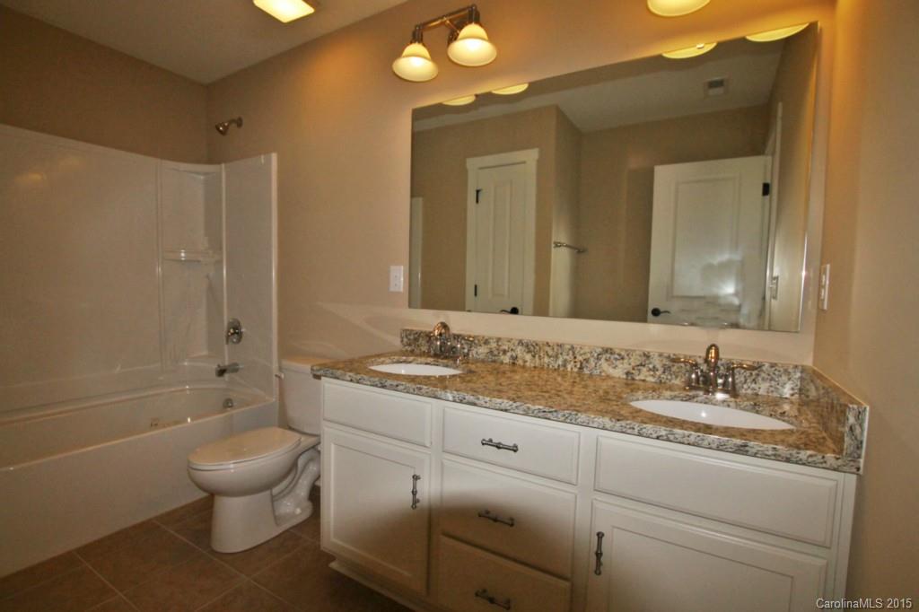 2207 Bluebell Way, Unit 14 Fort Mill, SC 29708 - Photo 15 of 20 a bathroom with a granite countertop sink toilet a large mirror and a bathtub