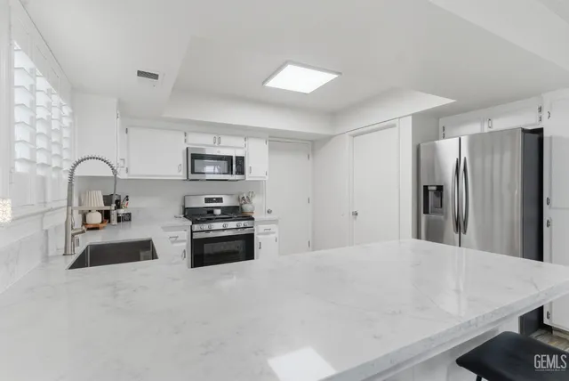 a kitchen with stainless steel appliances a refrigerator sink and stove