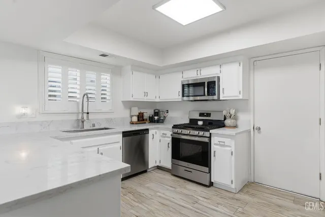 a kitchen with stainless steel appliances granite countertop a sink and a stove top oven