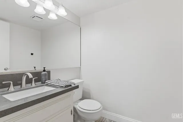 a bathroom with a sink a toilet and a mirror