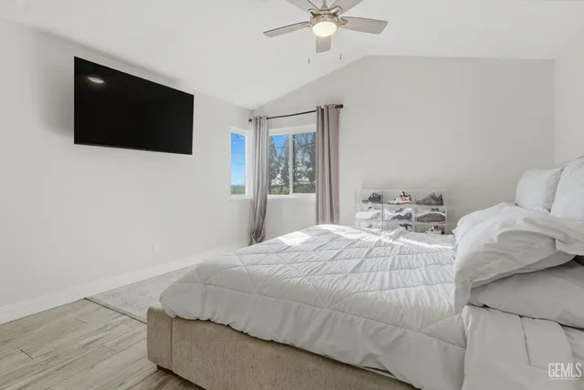 a bedroom with a bed tv and a window