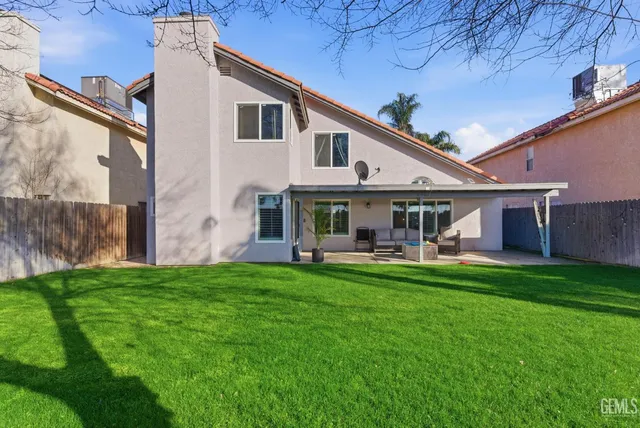 a view of a house with backyard and sitting area
