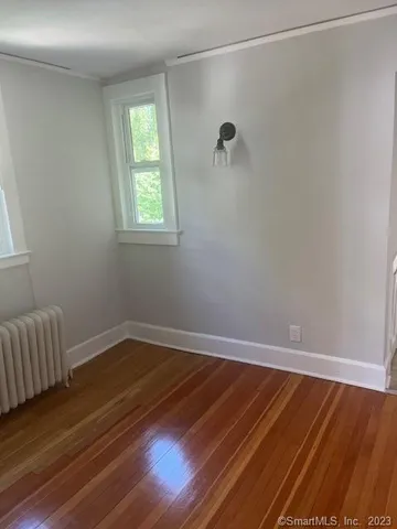 a room with a wooden floor and a window
