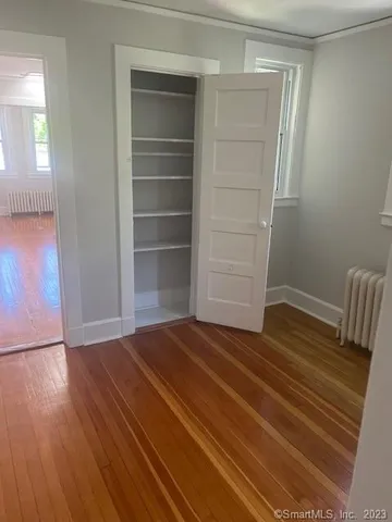a view of empty room with wooden floor and cabinet