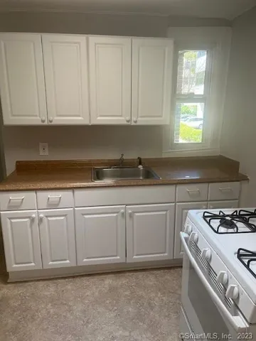 a kitchen with white cabinets and white appliances