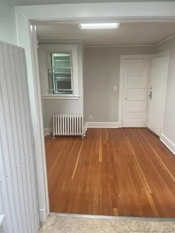 a view of a room with wooden floor and a window