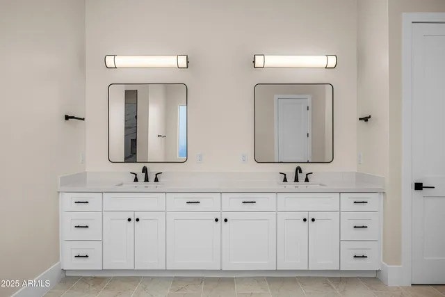 a bathroom with double sink and a mirror