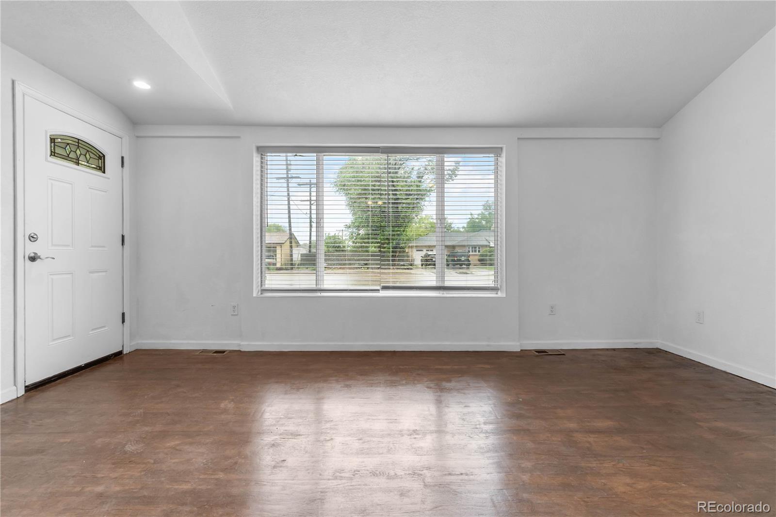7010 West 44th Avenue Wheat Ridge, CO 80033 - Photo 12 of 31 an empty room with wooden floor and windows