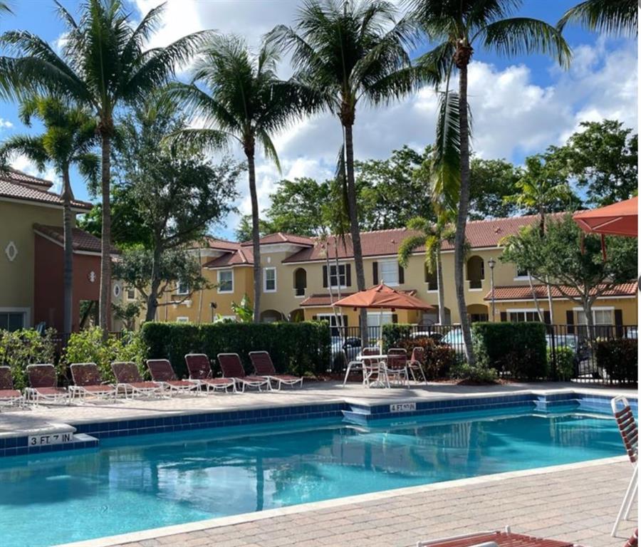 3389 Merrick Court Pompano Beach, FL 33063 - Photo 3 of 29 a front view of a house with swimming pool and a garden