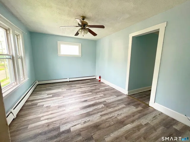 a view of empty room with windows and ceiling fan