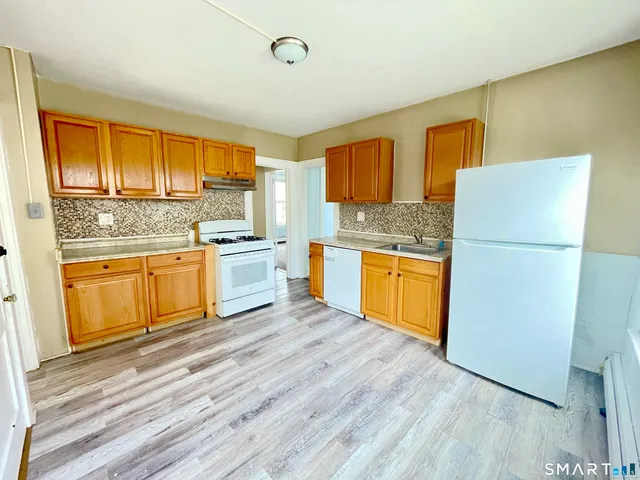 a kitchen with a stove a refrigerator and a sink