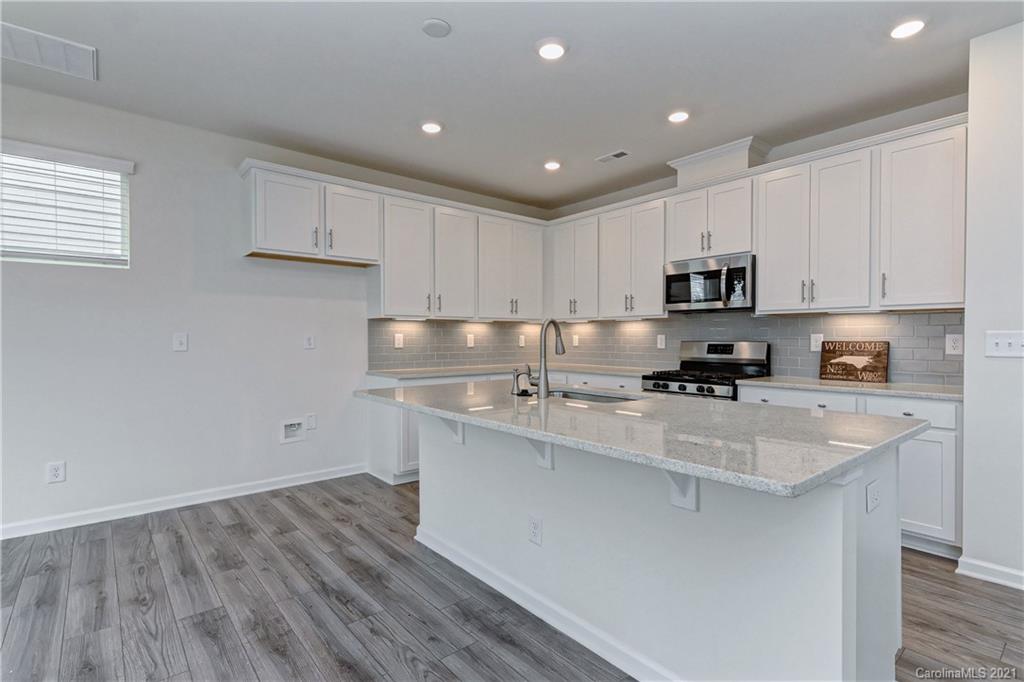 2014 Blue Pond Road Matthews, NC 28104 - Photo 11 of 32 a kitchen with stainless steel appliances granite countertop a sink a stove a refrigerator a center island and cabinets