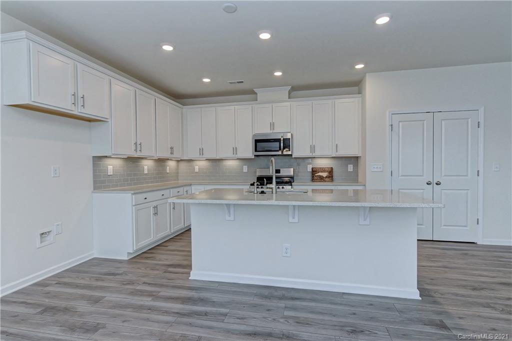 2014 Blue Pond Road Matthews, NC 28104 - Photo 12 of 32 a kitchen with kitchen island granite countertop a sink cabinets and wooden floor