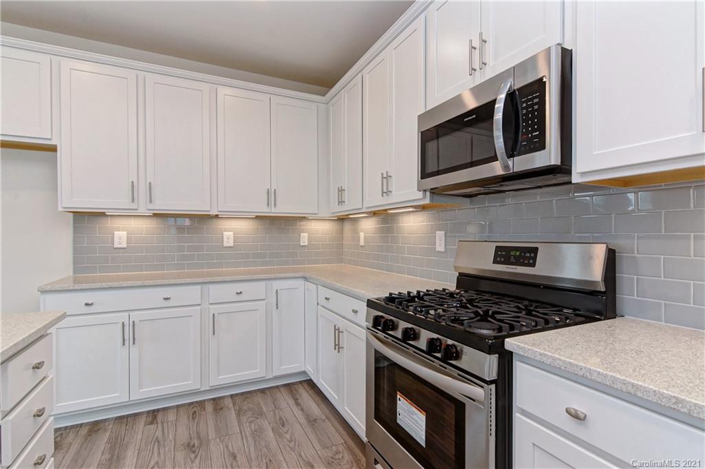 2014 Blue Pond Road Matthews, NC 28104 - Photo 15 of 32 a kitchen with stainless steel appliances granite countertop grey cabinets a stove a sink and dishwasher