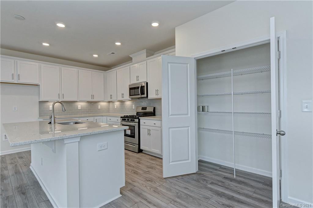 2014 Blue Pond Road Matthews, NC 28104 - Photo 16 of 32 a kitchen with stainless steel appliances granite countertop a sink a stove a refrigerator and cabinets