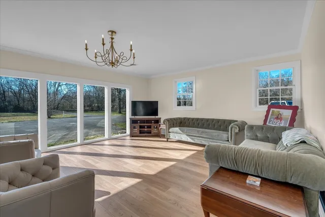 a view of a house with a big yard and large trees