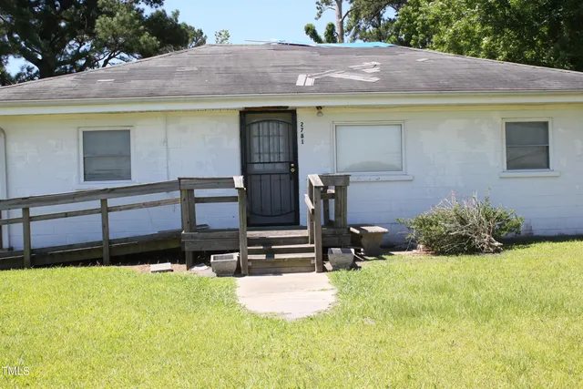 a view of a house with yard and sitting area