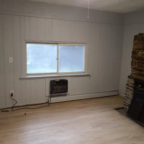 a view of a livingroom with an empty space and a window
