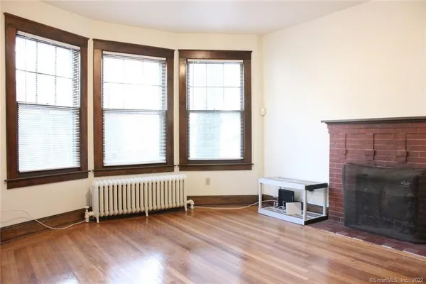a view of an empty room with a window and fireplace