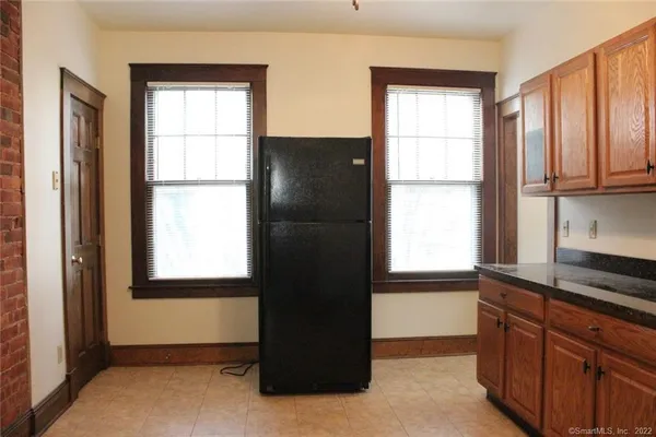 a kitchen with a window a refrigerator and cabinet