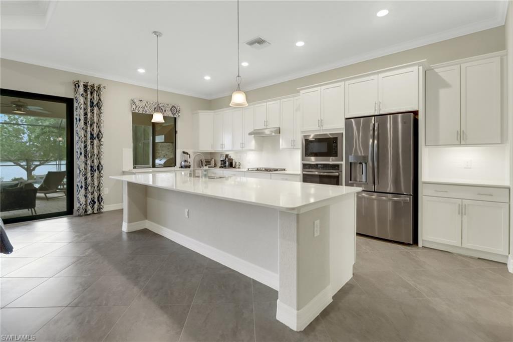 1878 Mustique Street Naples, FL 34120 - Photo 14 of 50 a large kitchen with a large counter top stainless steel appliances and cabinets