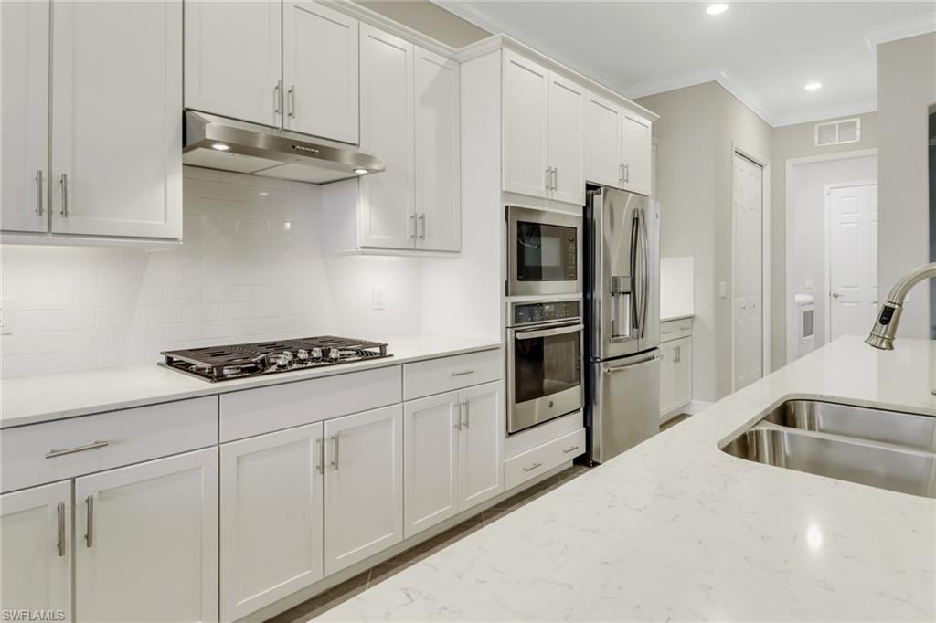 1878 Mustique Street Naples, FL 34120 - Photo 16 of 50 a kitchen with stainless steel appliances granite countertop a sink a stove and refrigerator