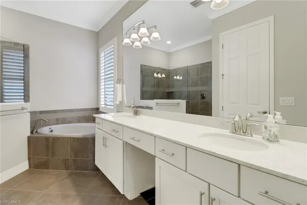 a spacious bathroom with a tub sink and mirror