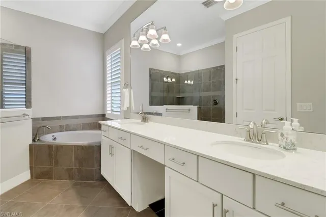 a spacious bathroom with a tub sink and mirror