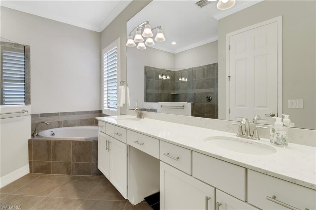1878 Mustique Street Naples, FL 34120 - Photo 26 of 50 a spacious bathroom with a tub sink and mirror